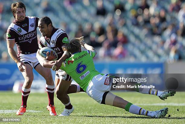 Steve Matai of the Sea Eagles is tackled by Blake Austin of the Raiders during the round 23 NRL match between the Canberra Raiders and the Manly...
