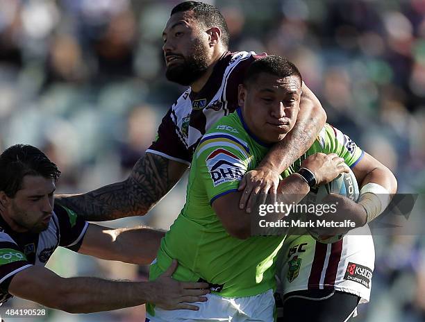 Josh Papalii of the Raiders is tackled during the round 23 NRL match between the Canberra Raiders and the Manly Warringah Sea Eagles at GIO Stadium...
