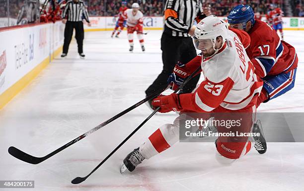 Brian Lashoff of the Detroit Red Wings tries to keep the puck from Rene Bourque of the Montreal Canadiens during the NHL game on April 5, 2014 at the...