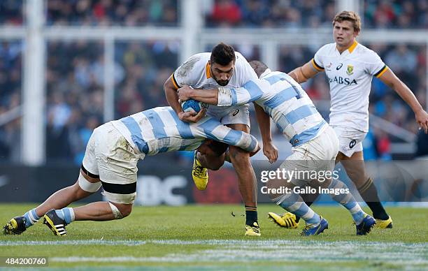 Damian de Allende of South Africa resist a tackle by Benjamin Macome of Argentina and Santiago Garcia Botta of Argentina during the International...