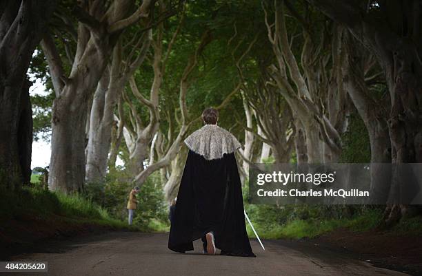 Game of Thrones tourist dressed in costume walks along a beech tree lined road known locally as The Dark Hedges on August 13, 2015 in Belfast,...