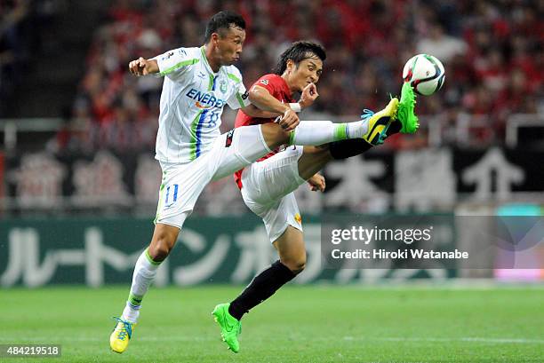 Yoshihito Fujita of Shonan Bellmare and Daisuke Nasu of Urawa Red Diamonds compete for the ball during the J.League match between Urawa Red Diamonds...