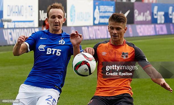 Alexei Kozlov of FC Dinamo Moscow is challenged by Alexander Martynovich of FC Ural Sverdlovsk Oblast during the Russian Premier League match between...