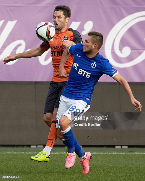 Alexander Tashaev of FC Dinamo Moscow is challenged by Denis Kulakov of FC Ural Sverdlovsk Oblast during the Russian Premier League match between...