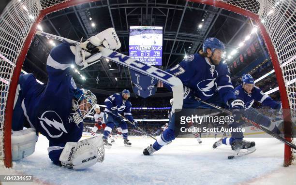 Goalie Kristers Gudlevskis of the Tampa Bay Lightning dives to make a save while Victor Hedman and Andrej Sustr look for the puck against the...