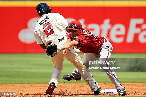 Nick Ahmed of the Arizona Diamondbacks reaches for an errant throw on a pick off attempt of Michael Bourn of the Atlanta Braves in the third inning...