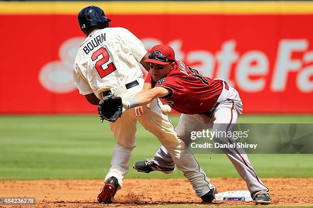 Nick Ahmed of the Arizona Diamondbacks reaches for an errant throw on a pick off attempt of Michael Bourn of the Atlanta Braves in the third inning...