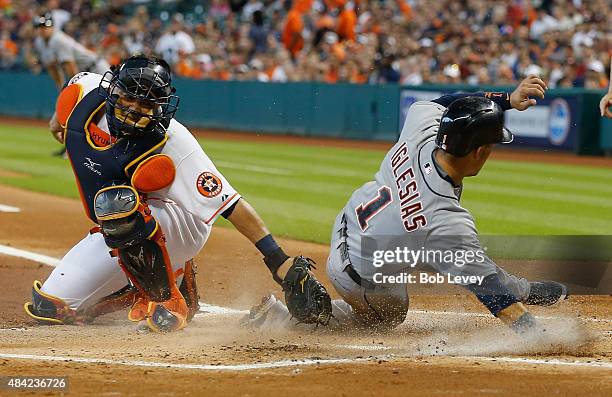 Jose Iglesias of the Detroit Tigers slides past the tag of Hank Conger of the Houston Astros in the first inning to score on a double by Miguel...