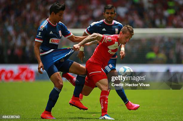 Carlos Cisneros of Chivas battles for the ball with Dario Bottinelli of Toluca during a 5th round match between Toluca and Chivas as part of the...