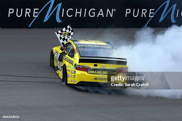 Matt Kenseth, driver of the Dollar General Toyota, celebrates with a burnout after winning the NASCAR Sprint Cup Series Pure Michigan 400 at Michigan...