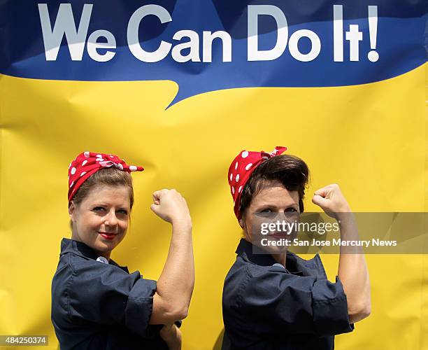 Jessica Curtis and Sarah Neller pose for a photograph in front of a "We Can Do It" backdrop as they joined with hundreds of women dressed as "Rosie...