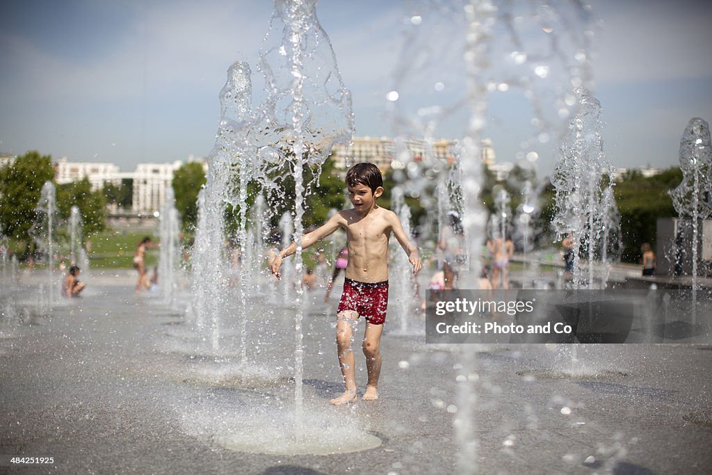 Child playing in a fountain with water jet