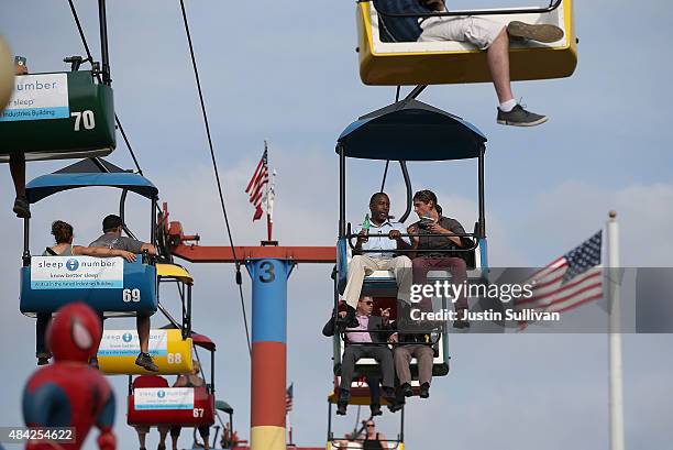 Republican presidential hopeful Ben Carson rides the Sky Glider with a reporter while touring the Iowa State Fair on August 16, 2015 in Des Moines,...