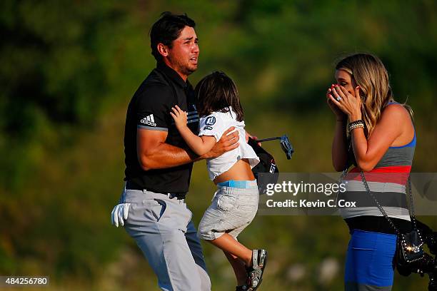 Jason Day of Australia celebrates on the 18th green with his son Dash and wife Ellie after winning the 2015 PGA Championship with a score of 20-under...