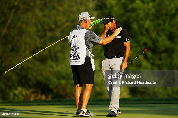 Jason Day of Australia celebrates with his caddie Colin Swatton on the 18th green after winning the 2015 PGA Championship with a score of 20-under...