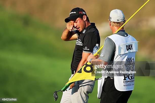 Jason Day of Australia celebrates with his caddie Colin Swatton on the 18th green after winning the 2015 PGA Championship with a score of 20-under...