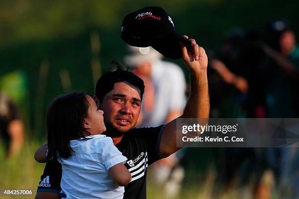 Jason Day of Australia walks off the 18th green with his son Dash after winning the 2015 PGA Championship with a score of 20-under par at Whistling...