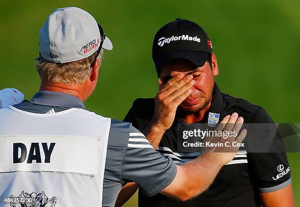 Jason Day of Australia celebrates with his caddie Colin Swatton on the 18th green after winning the 2015 PGA Championship with a score of 20-under...