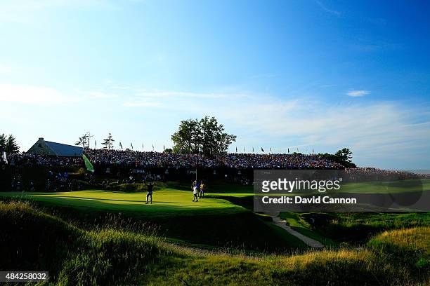 Fans watch as Jason Day of Australia celebrates on the 18th green after winning the 2015 PGA Championship with a score of 20-under par at Whistling...