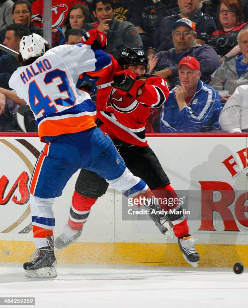 Stephen Gionta of the New Jersey Devils is checked off the puck by Mike Halmo of the New York Islanders during the game at the Prudential Center on...