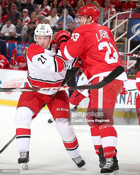 Brian Lashoff of the Detroit Red Wings hits Drayson Bowman of the Carolina Hurricanes during an NHL game on April 11, 2014 at Joe Louis Arena in...