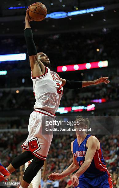 Taj Gibson of the Chicago Bulls goes up for a dunk over Kyle Singler of the Detroit Pistons at the United Center on April 11, 2014 in Chicago,...