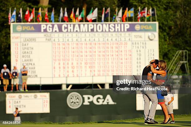 Jason Day of Australia celebrates on the 18th green with his wife Ellie and son Dash after winning the 2015 PGA Championship with a score of 20-under...