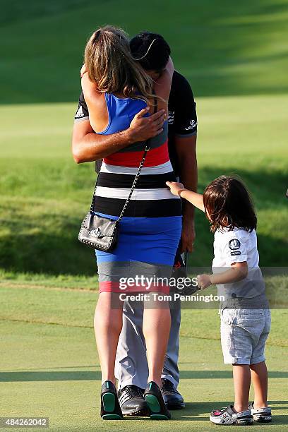 Jason Day of Australia celebrates on the 18th green with his wife Ellie and son Dash after winning the 2015 PGA Championship with a score of 20-under...