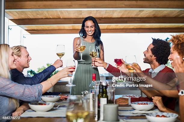 woman hosting a dinner party - party host stock-fotos und bilder