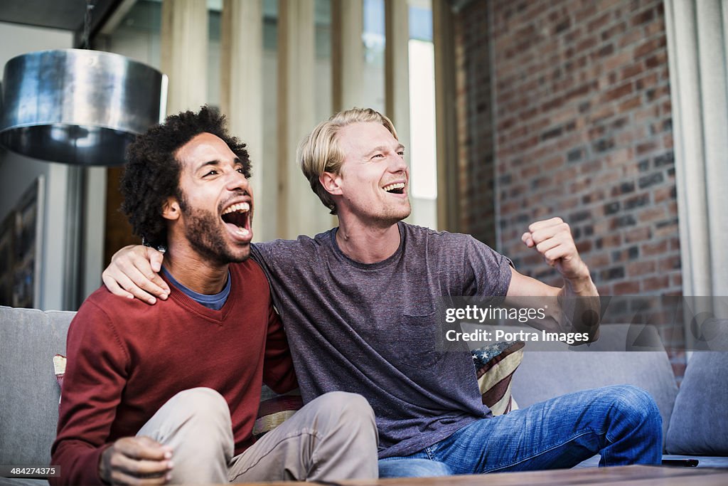 Two friends watching sports on tv
