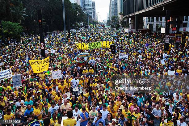 Demonstrators hold banners and signs during a protest in Sao Paulo, Brazil, on Sunday, Aug. 16, 2015. Nationwide street protests Sunday against...