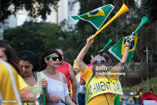 Demonstrator waves Brazilian flags during a protest in Sao Paulo, Brazil, on Sunday, Aug. 16, 2015. Nationwide street protests Sunday against...