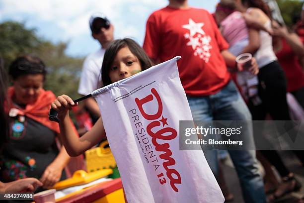 Child holds a banner supporting Brazilian President Dilma Rousseff during a protest in Sao Paulo, Brazil, on Sunday, Aug. 16, 2015. Nationwide street...