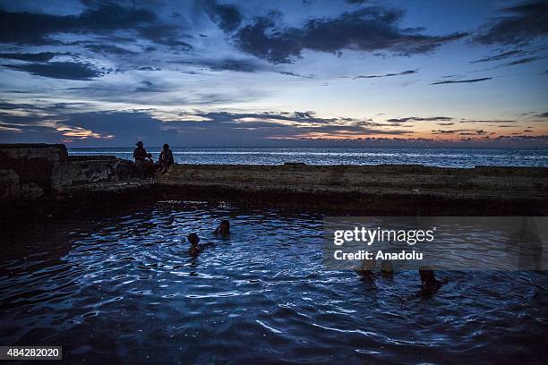 Cubans swim in a coastal pool as the sun sets along the Gulf of Mexico in the Miramar neighborhood of Havana, Cuba on August 14, 2015.