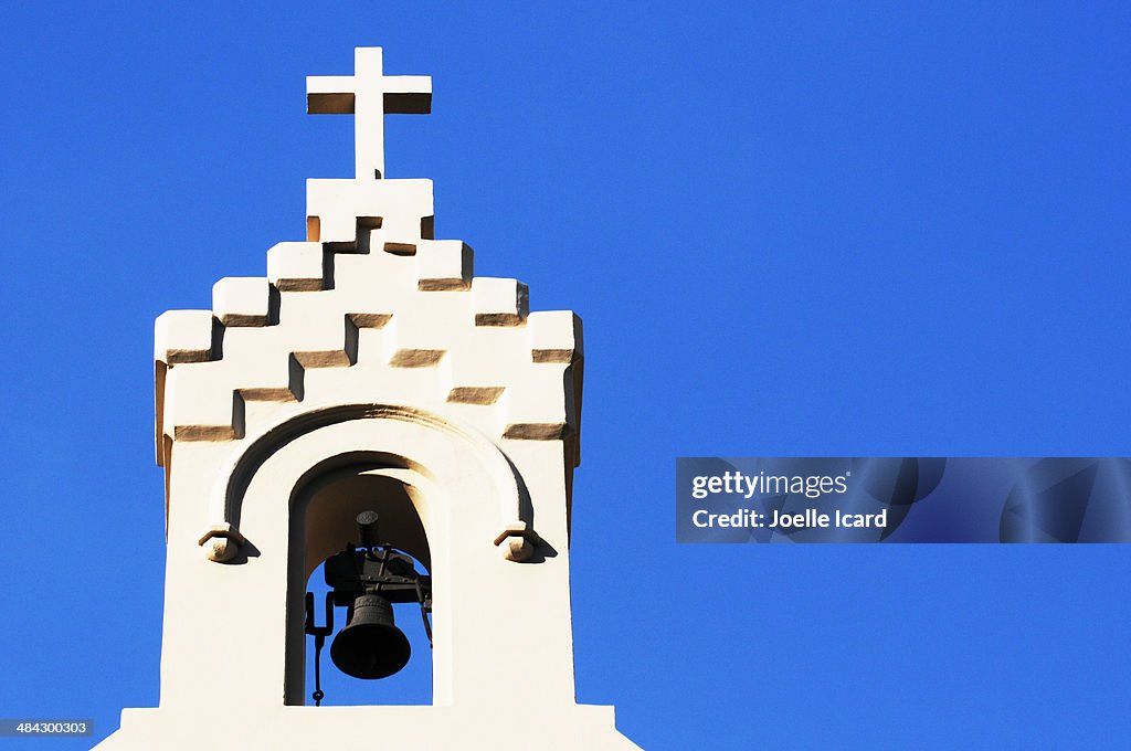 Bells and a cross at the top of a church