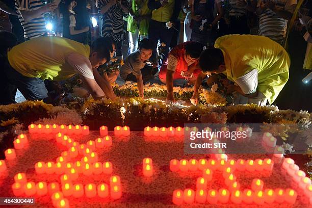 This picture taken on August 16, 2015 shows residents laying flowers and lighting candles at the crossroads outside Tianjin Taida hospital at a vigil...
