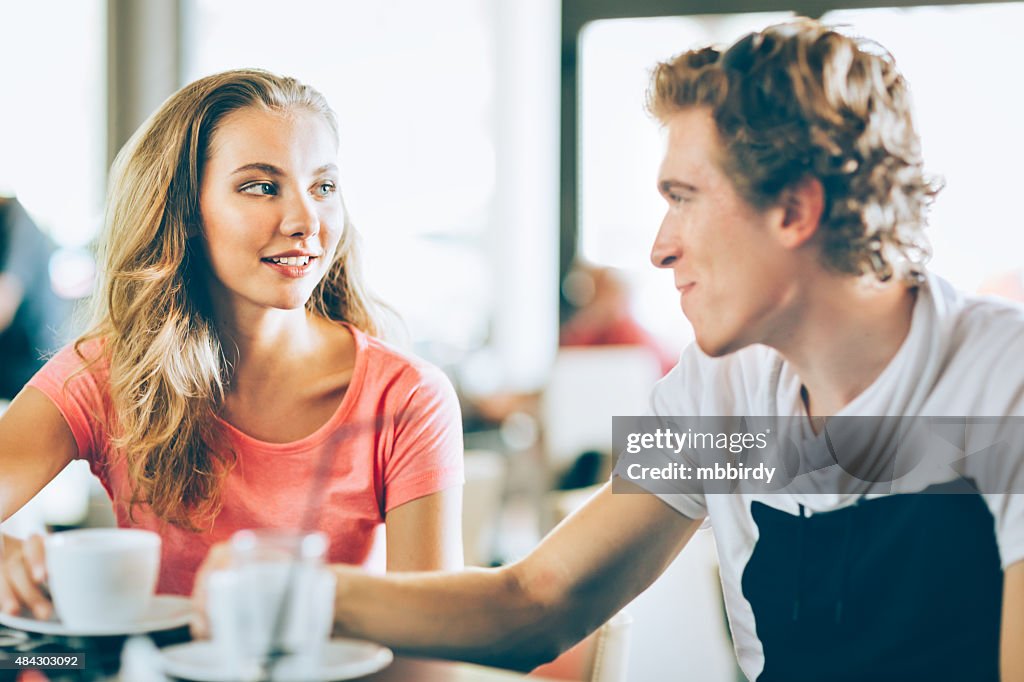 Young couple talking with each other in cafe