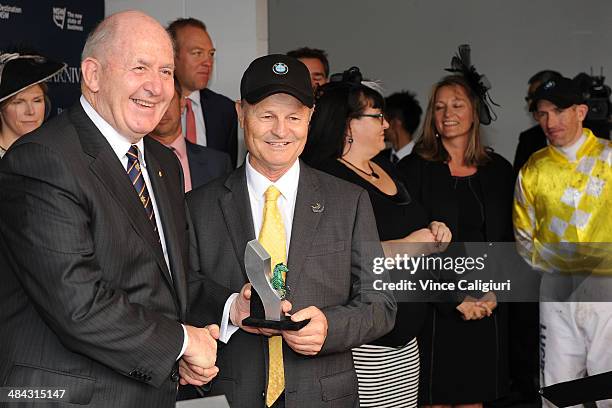 Governor General, Sir Peter Cosgrove presents trainer David Payne with trophy after Criterion won Race 6, the BMW Australian Derby during day one of...