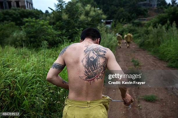 Chinese actor playing a Nationalist soldier takes off his costume after filming segment of the series "Legend of the Stupid Guy" set during the...