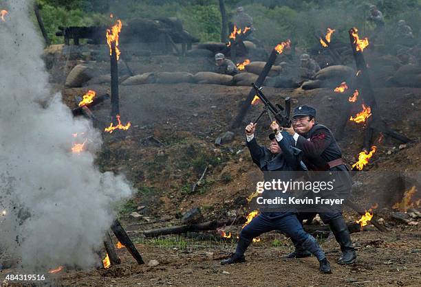 Chinese actors playing Nationalist soldiers hold a gin during filming of a battle segment in the series "Legend of the Stupid Guy" set during the...