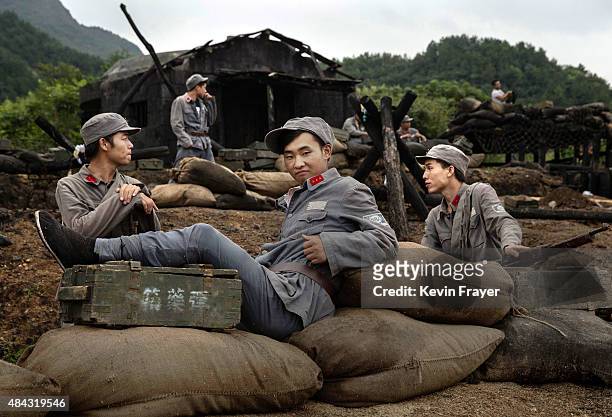 Chinese actors playing Nationalist soldiers wait during filming of a battle segment in the series "Legend of the Stupid Guy" set during the second...