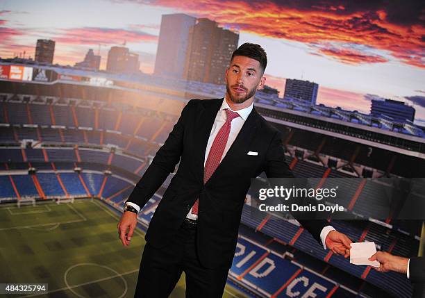 Sergio Ramos of Real Madrid takes a note from the Real press officer during a press conference to announce his new five-year contract with Real...