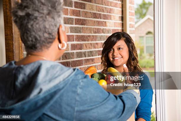 volunteers:  young adult brings groceries to senior woman at home. - delivery character stock pictures, royalty-free photos & images