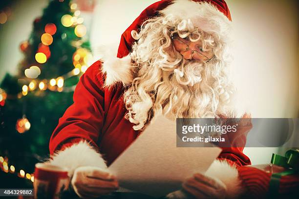 santa claus reading letters and wishlists. - important message stockfoto's en -beelden