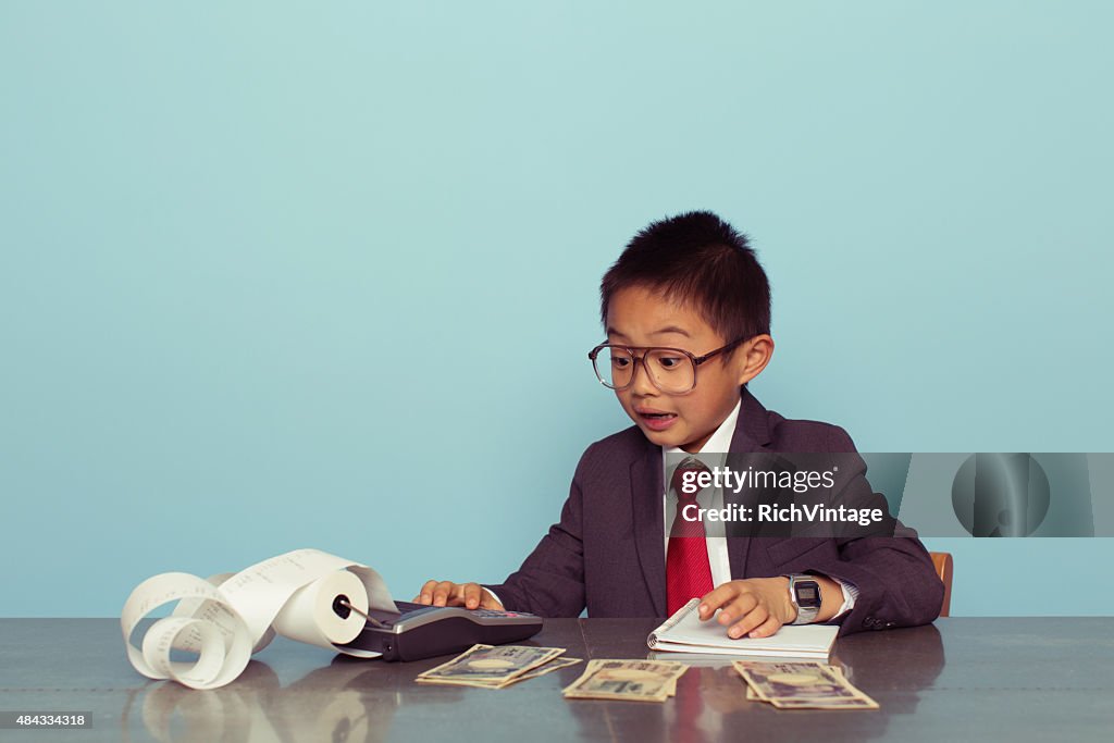 Young Japanese Boy Accountant in Business Suit Adds Numbers