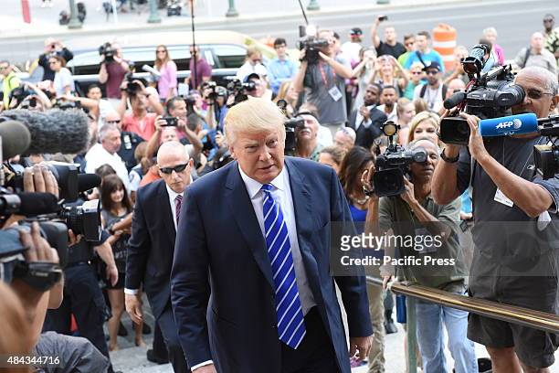 Republican front-runner Donald Trump ascends steps of Manhattan Supreme Court surrounded by press. Republican presidential nomination front runner...