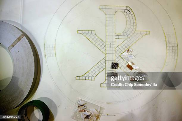 Drawing of a papal seal that will adorne furnishings that Pope Francis will use during his upcoming visit to the United States sits on a work bench...
