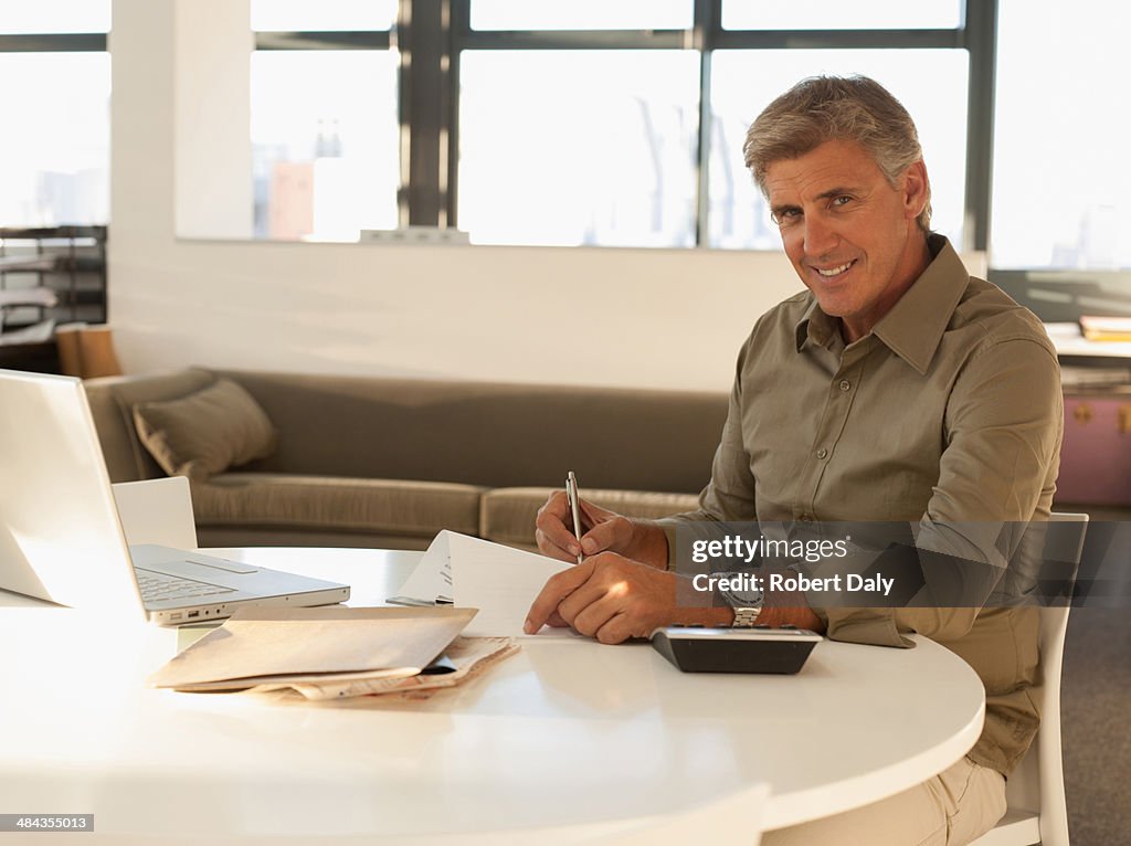 Businessman filling out paperwork in office