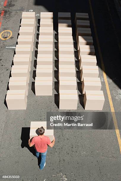 man carrying box in roadway - preciseness stock pictures, royalty-free photos & images