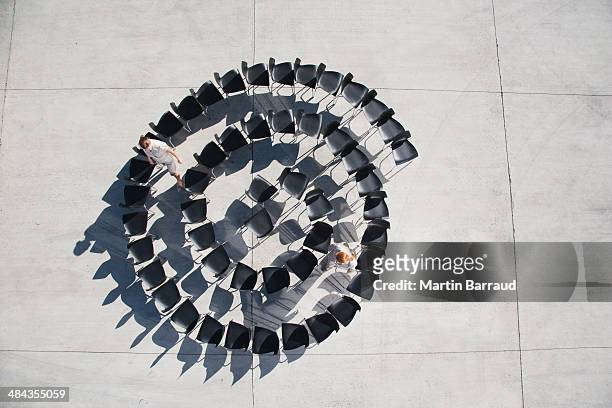 two businesswomen standing with spiral of office chairs - same people different clothes stock pictures, royalty-free photos & images